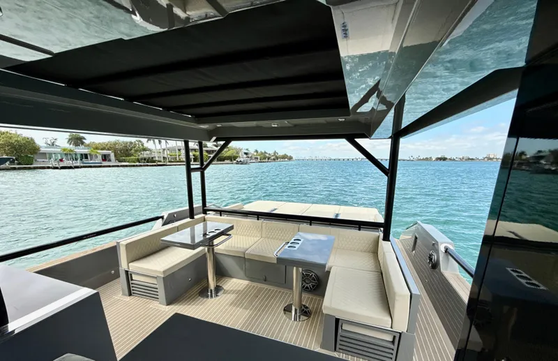  Yacht Photos Pics 2023 De Antonio Yachts D50 Coup&eacute;, luxurious deck view with seating, overlooking serene waters.