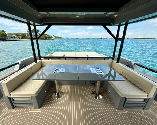  Yacht Photos Pics 2023 De Antonio Yachts D50 Coup&eacute; deck with seating and table, overlooking serene waters.