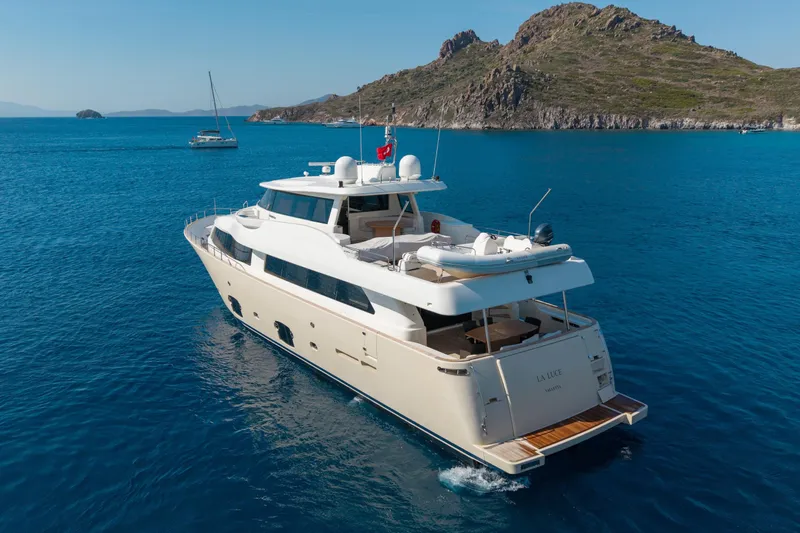 La Luce Yacht Photos Pics Luxury yacht Custom Line Navetta 26, 2008, cruising in clear blue waters near rocky coastline.
