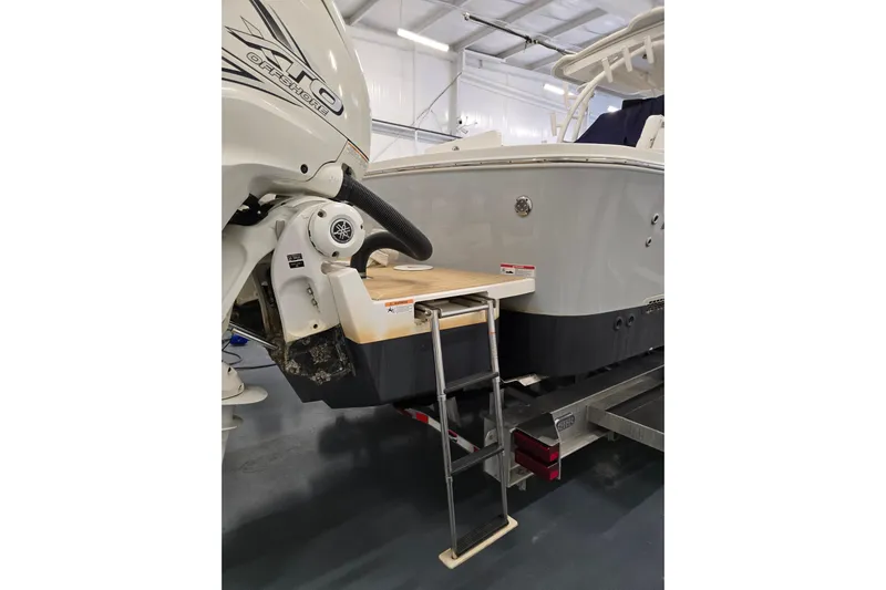  Yacht Photos Pics 2020 Regulator 41 boat with ladder and outboard motor in a garage setting.