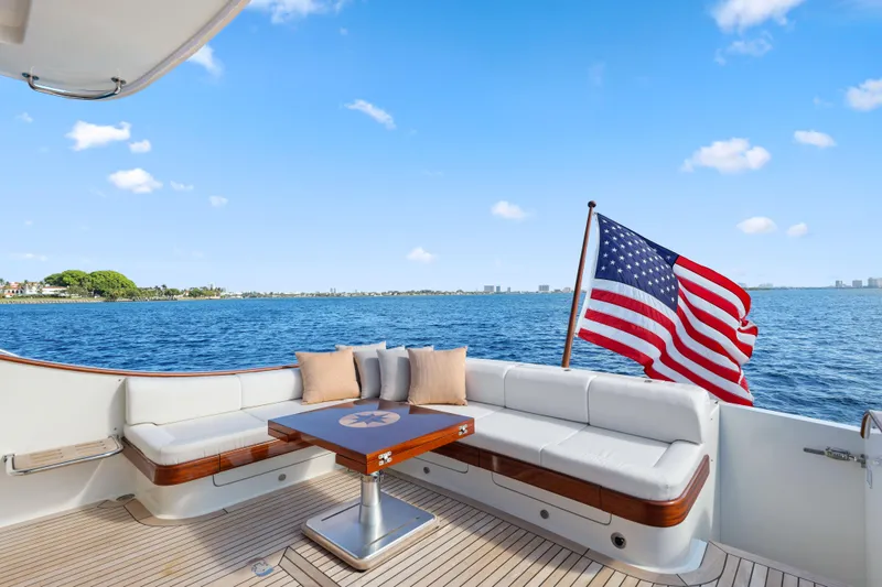 Bebe Deux Yacht Photos Pics 2023 Vicem 65 Classic yacht deck with American flag, ocean view, and seating area.