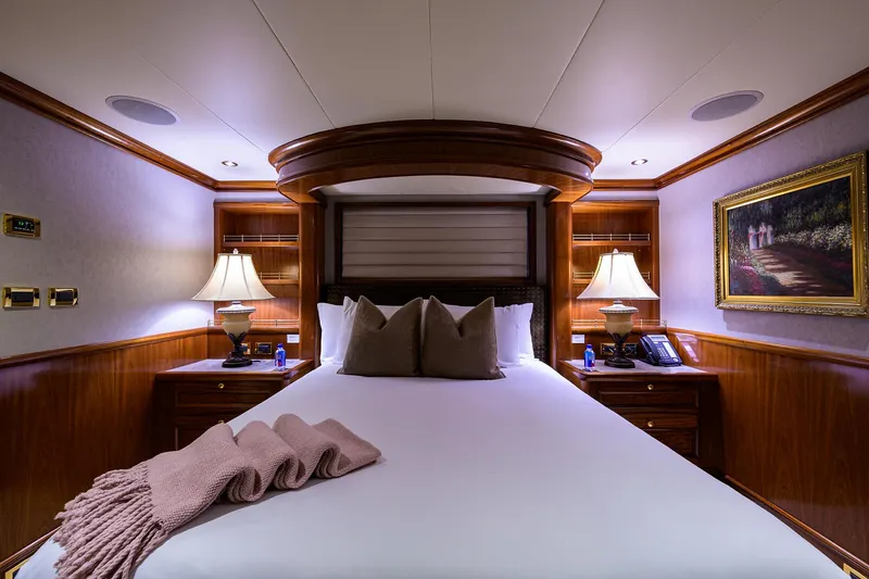 Excellence Yacht Photos Pics Luxurious bedroom interior on 2010 Richmond Yachts 150, featuring elegant wood paneling and ambient lighting.