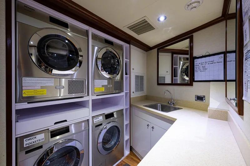 Excellence Yacht Photos Pics Laundry room on 2010 Richmond Yachts 150, featuring stacked washers, dryers, and a countertop sink.