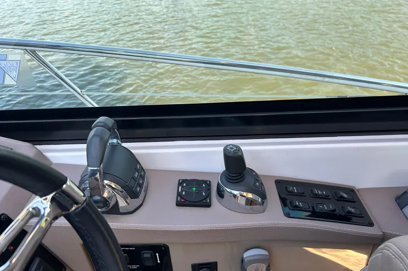  Yacht Photos Pics Control panel of a 2018 Regal 42 Sport Coupe yacht with steering wheel and throttle.