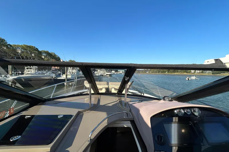  Yacht Photos Pics 2018 Regal 42 Sport Coupe navigating a scenic waterway under clear blue skies.