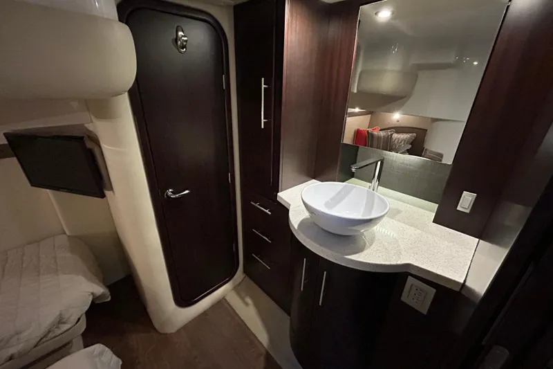  Yacht Photos Pics Luxurious interior of 2018 Regal 42 Sport Coupe with modern sink and dark wood finishes.