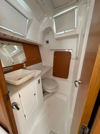  Yacht Photos Pics 2021 Dufour 360 yacht bathroom with modern fixtures and wood accents.