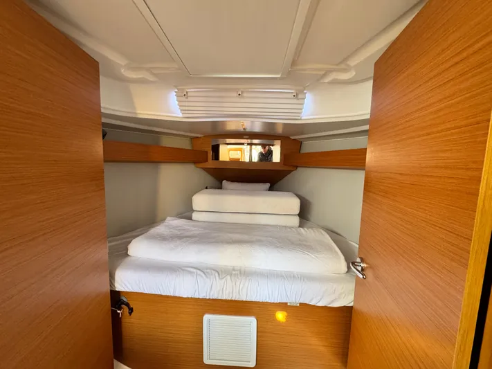  Yacht Photos Pics Interior cabin of 2021 Dufour 360 yacht with cozy bed and wooden finish.