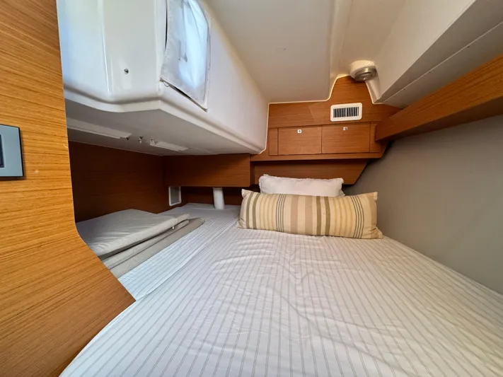  Yacht Photos Pics Cozy cabin interior of 2021 Dufour 360 yacht with striped bedding.
