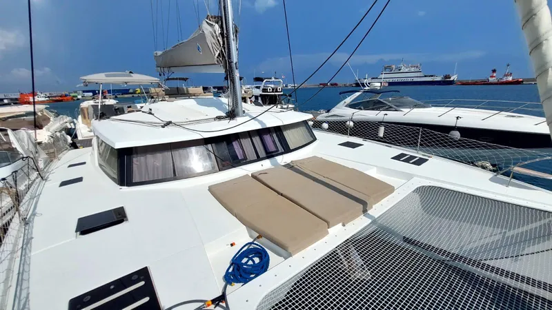  Yacht Photos Pics 2018 Fountaine Pajot Saona 47 catamaran docked at marina, featuring spacious deck and netting.