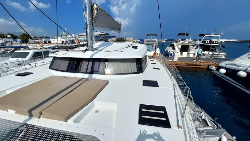  Yacht Photos Pics 2018 Fountaine Pajot Saona 47 catamaran docked at marina, clear sky, calm waters.