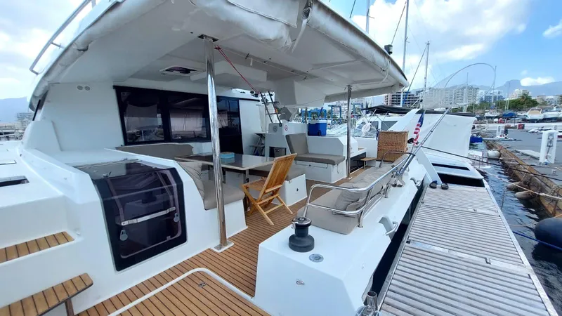  Yacht Photos Pics 2018 Fountaine Pajot Saona 47 catamaran docked, featuring spacious outdoor seating and modern design.