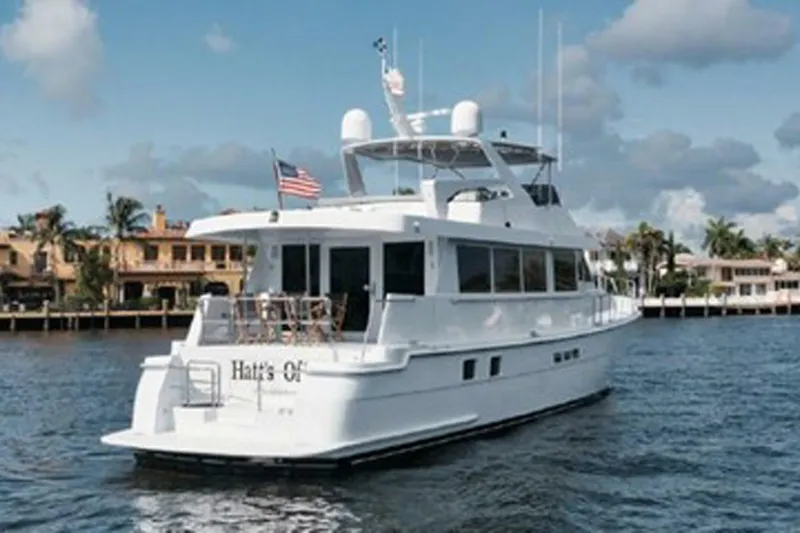 Hatt's Off Yacht Photos Pics 1998 Hatteras 74 Cockpit Motor Yacht cruising on a sunny day near waterfront homes.