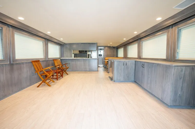 Hatt's Off Yacht Photos Pics Interior of 1998 Hatteras 74 Cockpit Motor Yacht with wooden chairs and cabinetry.