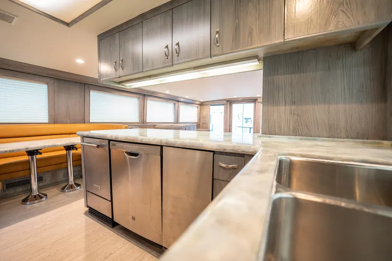 Hatt's Off Yacht Photos Pics Interior of 1998 Hatteras 74 Cockpit Motor Yacht with modern kitchen and dining area.