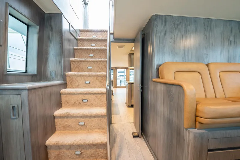 Hatt's Off Yacht Photos Pics Interior of 1998 Hatteras 74 Cockpit Motor Yacht with stairs and seating area.