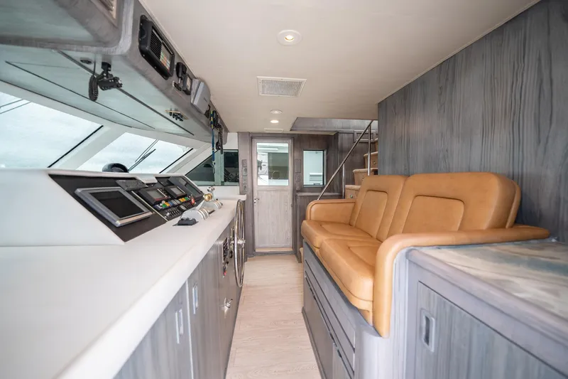 Hatt's Off Yacht Photos Pics Interior of 1998 Hatteras 74 Cockpit Motor Yacht with leather seating and control panel.