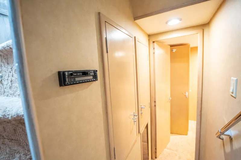 Hatt's Off Yacht Photos Pics Interior hallway of 1998 Hatteras 74 Cockpit Motor Yacht with wood paneling and lighting.