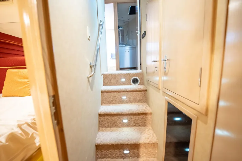 Hatt's Off Yacht Photos Pics Interior of 1998 Hatteras 74 Cockpit Motor Yacht with carpeted stairs and wooden cabinetry.