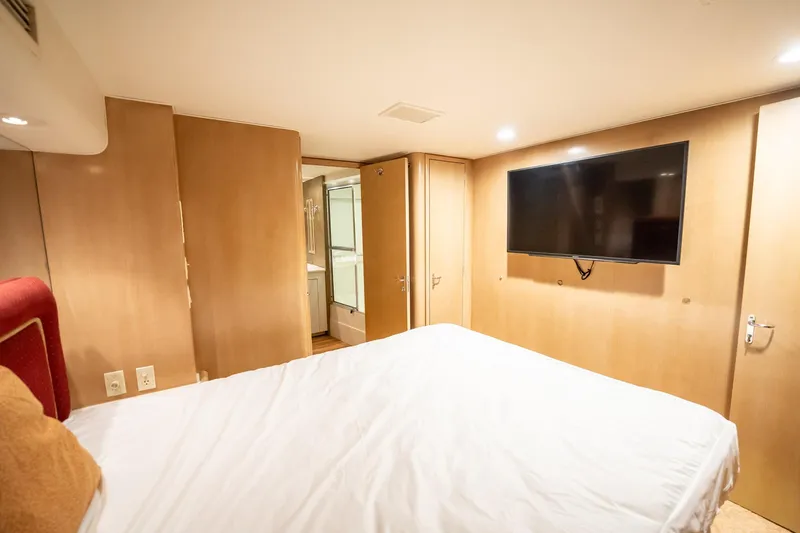 Hatt's Off Yacht Photos Pics Bedroom interior of 1998 Hatteras 74 Cockpit Motor Yacht with TV and ensuite bathroom.