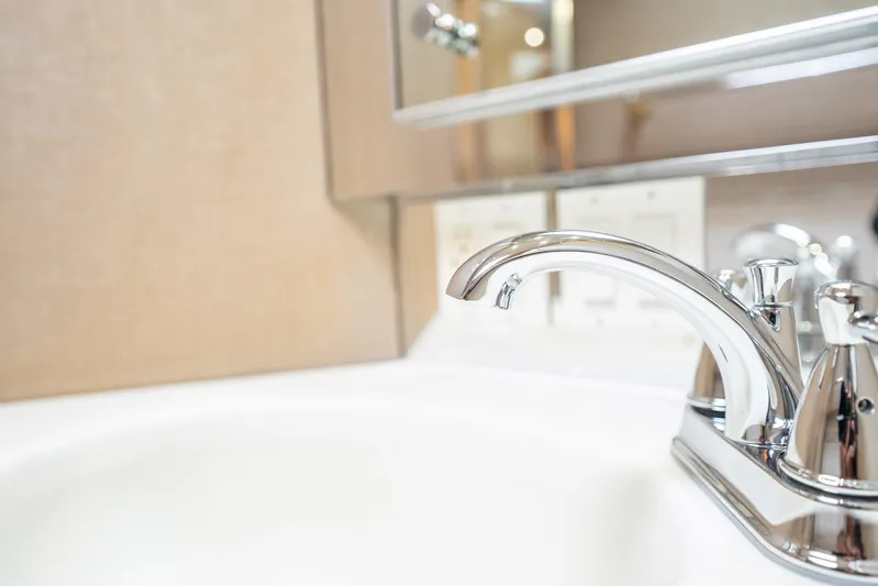 Hatt's Off Yacht Photos Pics Chrome faucet in the bathroom of a 1998 Hatteras 74 Cockpit Motor Yacht.