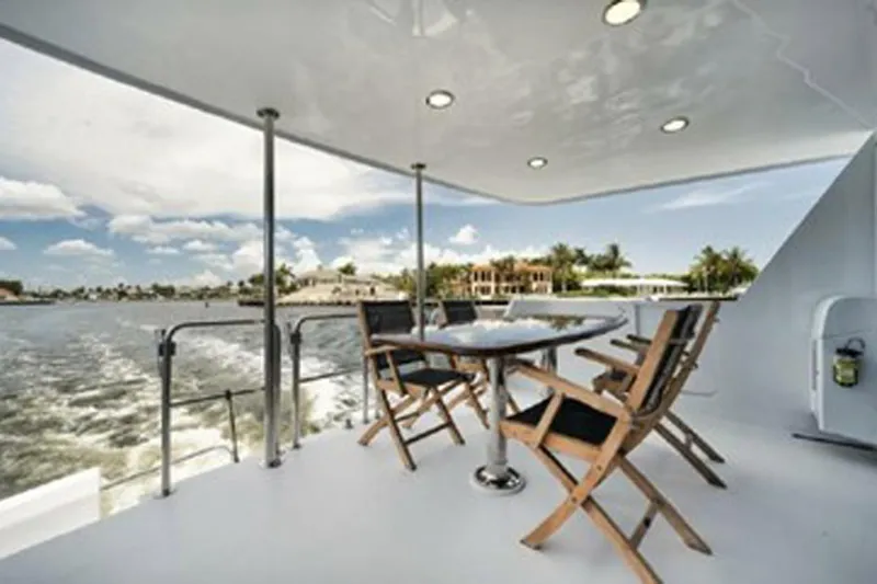 Hatt's Off Yacht Photos Pics Outdoor seating on 1998 Hatteras 74 Cockpit Motor Yacht, with ocean view and clear skies.