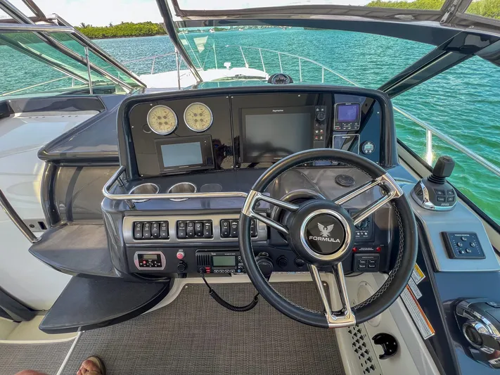 Liquid Asset Yacht Photos Pics Cockpit view of a 2017 Formula 40 PC yacht with steering wheel and control panel.