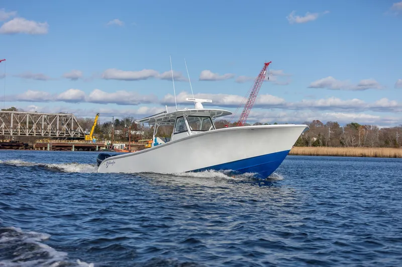 Yacht Photos Pics 2018 Yellowfin 39 Offshore boat cruising on a river with a bridge in the background.