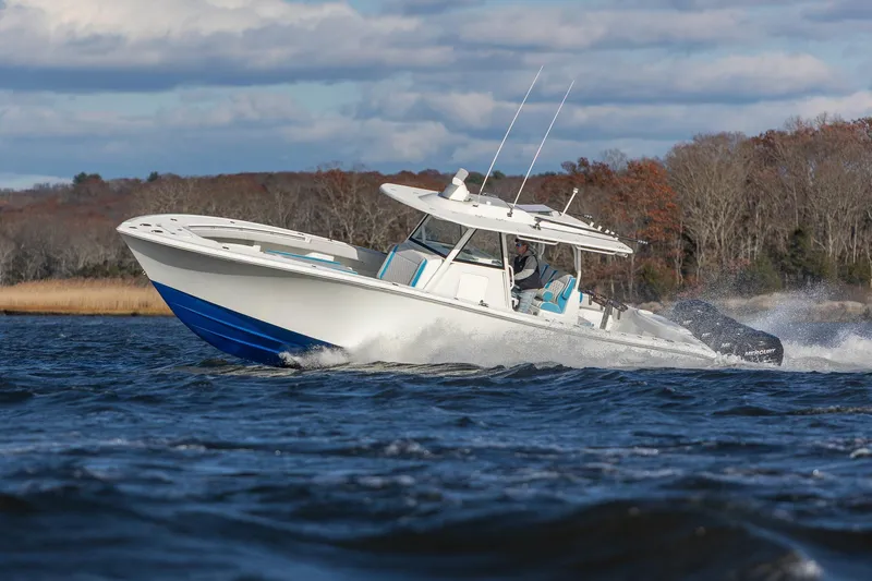 Yacht Photos Pics 2018 Yellowfin 39 Offshore boat cruising on a lake with scenic background.