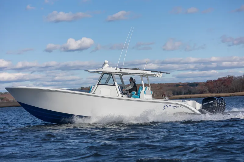  Yacht Photos Pics 2018 Yellowfin 39 Offshore boat cruising on a lake under a partly cloudy sky.