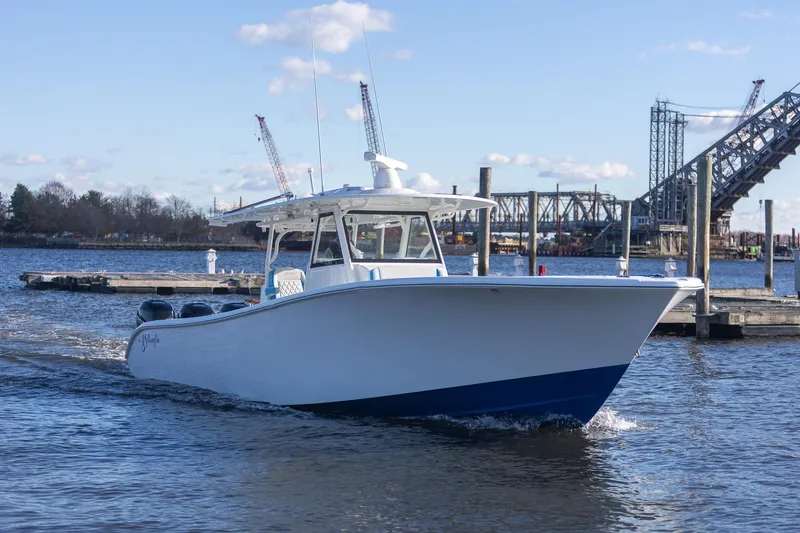  Yacht Photos Pics 2018 Yellowfin 39 Offshore boat cruising near a dock with bridge in background.