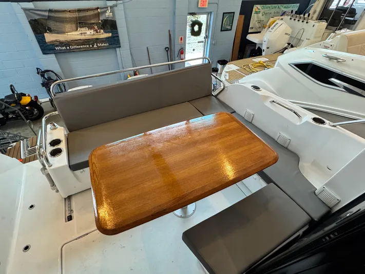  Yacht Photos Pics 2022 Beneteau Antares 9 interior with wooden table and gray seating.