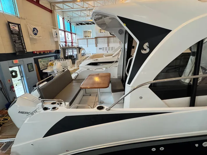  Yacht Photos Pics 2022 Beneteau Antares 9 boat interior with seating and table in showroom.