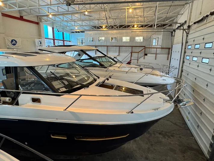  Yacht Photos Pics 2022 Beneteau Antares 9 boats in a well-lit indoor storage facility.