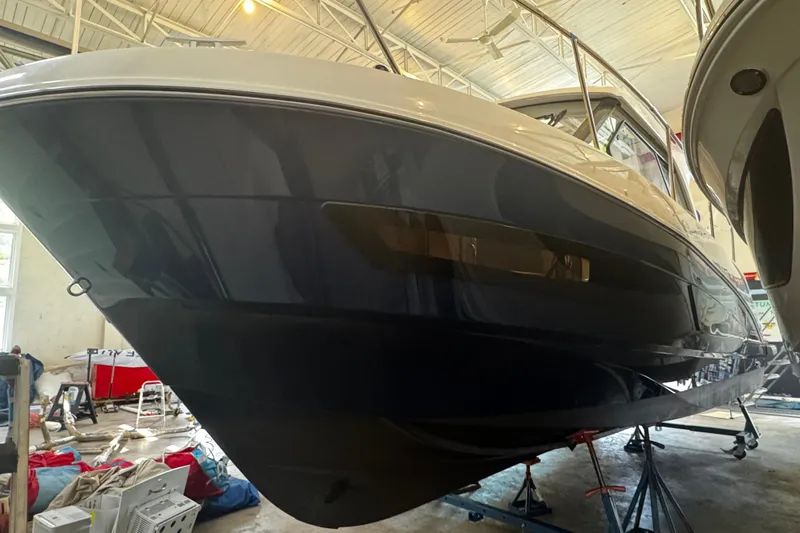  Yacht Photos Pics 2022 Beneteau Antares 9 boat in a workshop, side view.