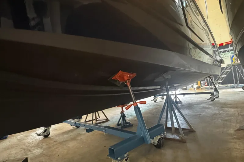  Yacht Photos Pics 2022 Beneteau Antares 9 boat hull on stands in a workshop.