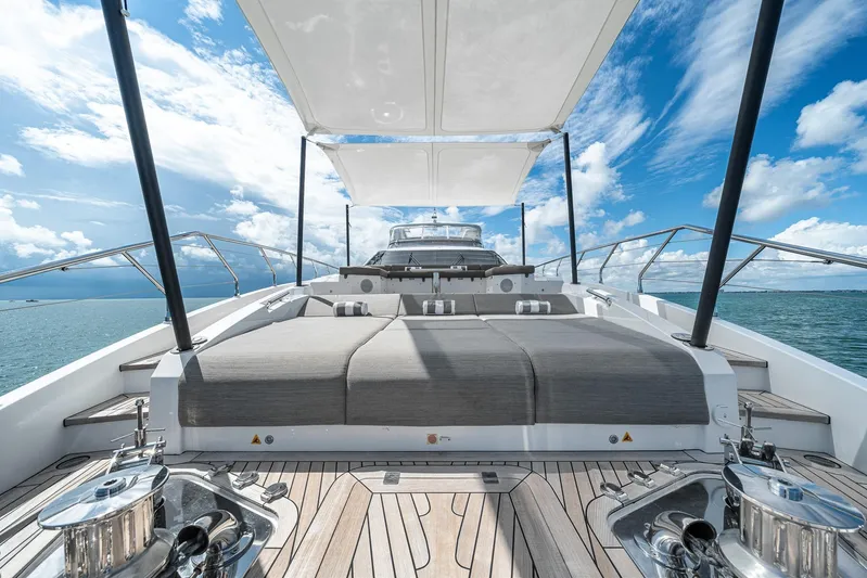 No Name Yacht Photos Pics Luxurious Azimut Grande 27 METRI yacht deck with sunbeds, 2022 model, under a clear blue sky.