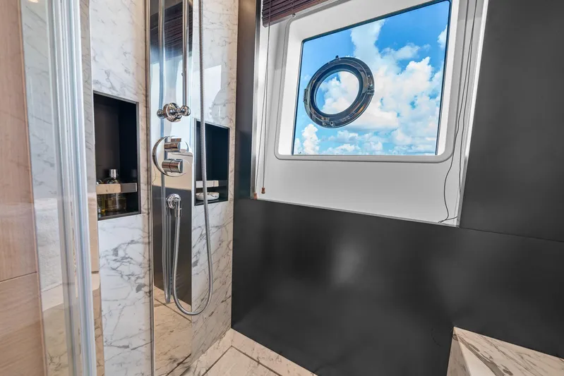 No Name Yacht Photos Pics Luxurious bathroom with marble accents on Azimut Grande 27 METRI yacht, featuring a scenic porthole view.