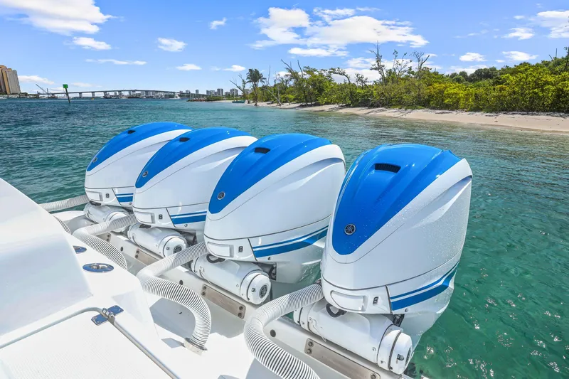 Polar II Yacht Photos Pics Four blue and white outboard motors on a 2020 HCB 53 boat near a tropical shoreline.