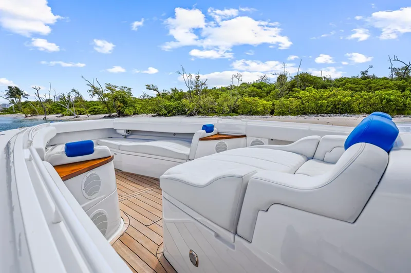 Polar II Yacht Photos Pics Luxurious 2020 HCB 53 boat interior with white seating and blue accents, near lush greenery.