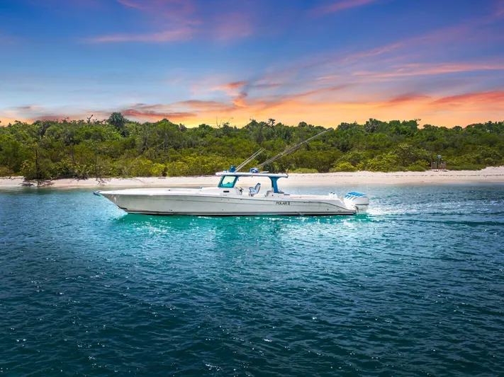 Polar II Yacht Photos Pics 2020 HCB 53 boat cruising near a tropical shoreline at sunset.