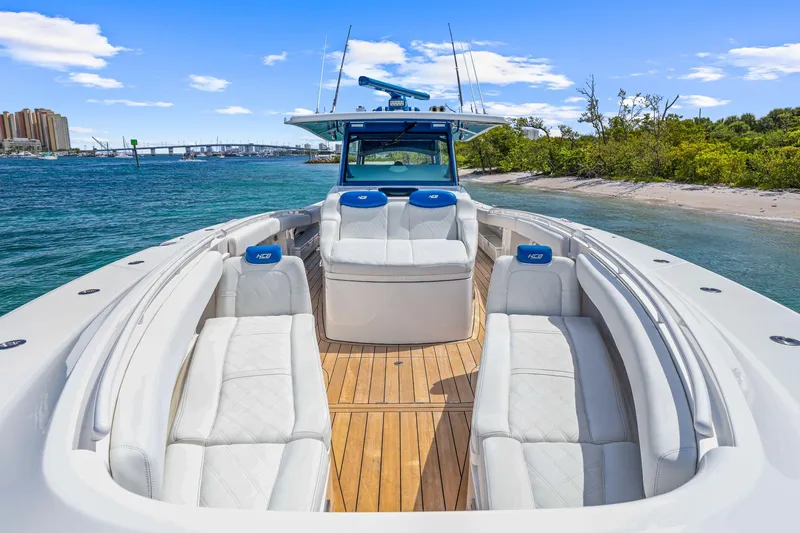 Polar II Yacht Photos Pics Luxurious 2020 HCB 53 boat with spacious seating, docked near a scenic shoreline.