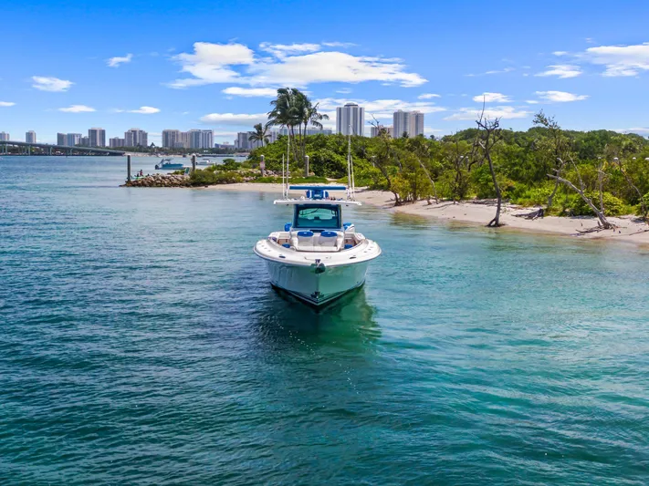 Polar II Yacht Photos Pics 2020 HCB 53 boat near tropical shoreline with city skyline in background.