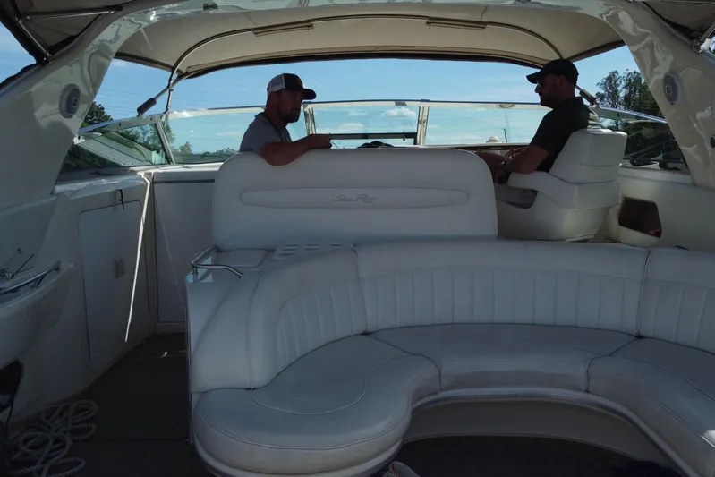  Yacht Photos Pics Interior of a 1997 Sea Ray 450 Sundancer with two people seated, featuring white leather seating.