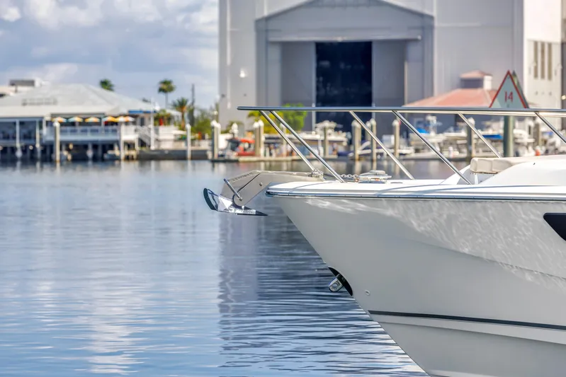  Yacht Photos Pics 2023 Boston Whaler 405 Conquest boat docked in a marina, calm water, and buildings in background.