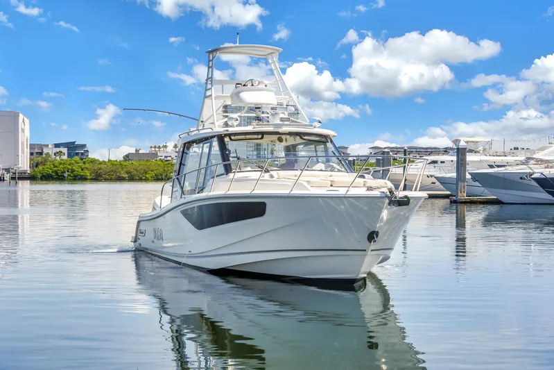  Yacht Photos Pics 2023 Boston Whaler 405 Conquest boat on calm water under a bright blue sky.
