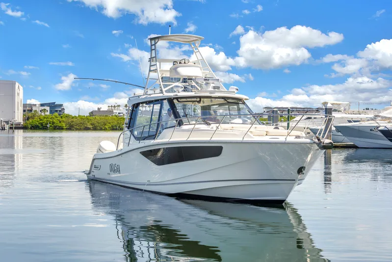  Yacht Photos Pics 2023 Boston Whaler 405 Conquest boat on calm water under a bright blue sky.