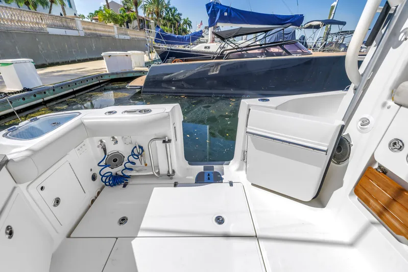  Yacht Photos Pics 2023 Boston Whaler 405 Conquest boat deck with open door, docked near other boats.