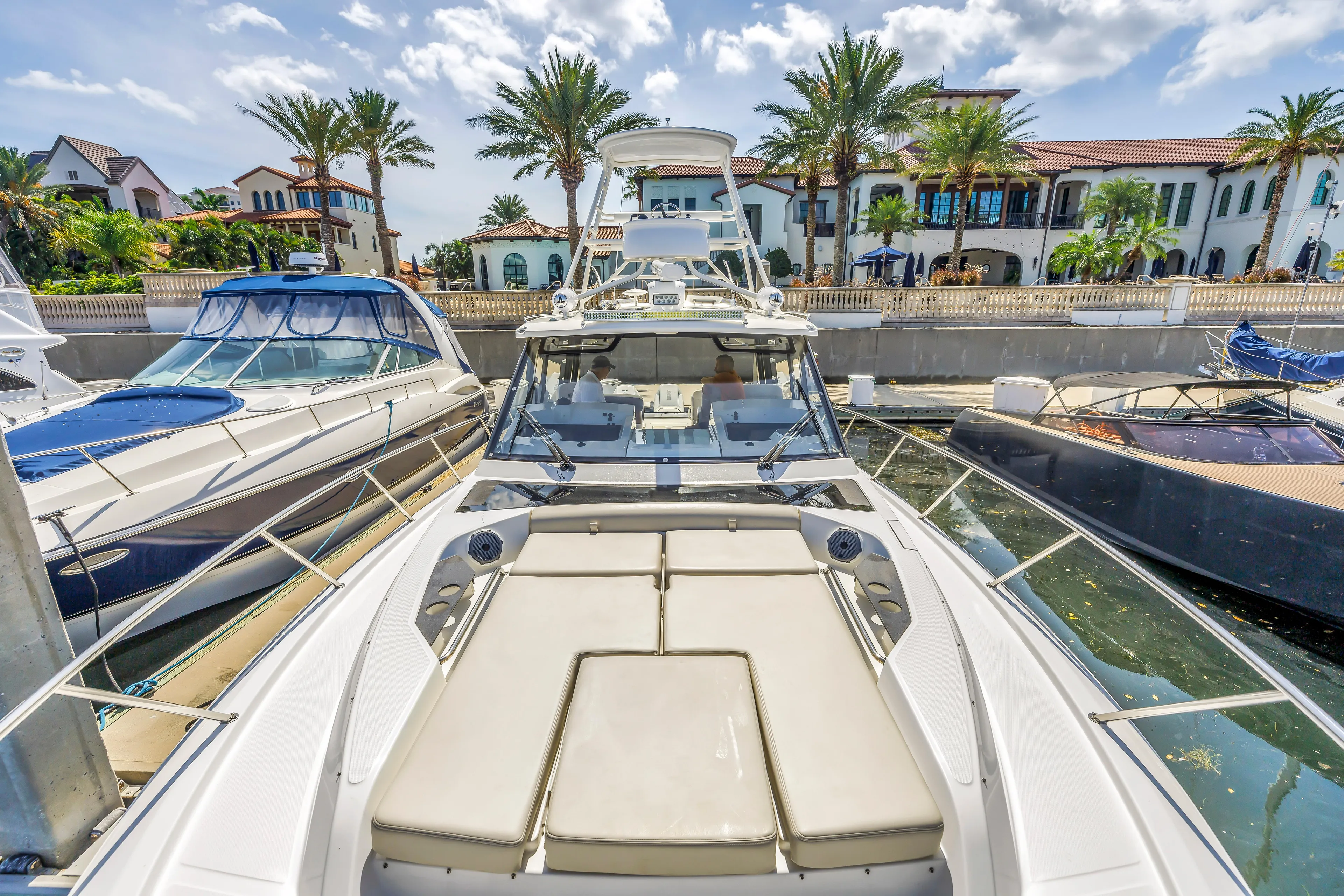  Yacht Photos Pics 2023 Boston Whaler 405 Conquest docked, surrounded by luxury yachts and palm trees.