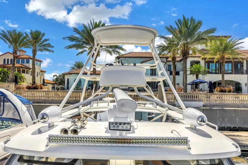  Yacht Photos Pics 2023 Boston Whaler 405 Conquest yacht docked near luxury waterfront homes, palm trees, and blue sky.